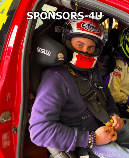 A person wearing a helmet and safety harness, seated in a racing car.